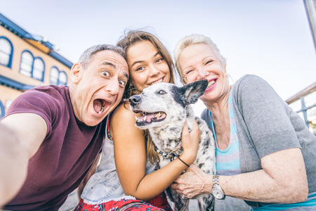Self portrait of happy family with dog having fun outdoors - Grandparents and nephew taking a selfieの写真素材