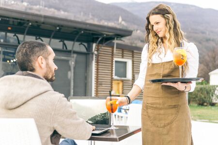 Seductive waitress bring aperitif to the customer.concept about professions and jobsの写真素材