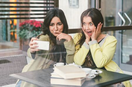 Crazy friends taking selfie in a bar with smart phoneの写真素材