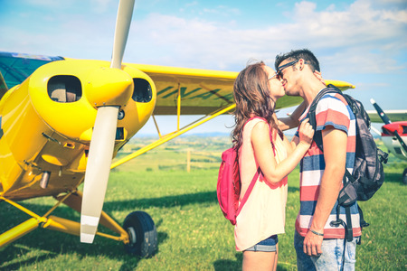 Couple kissing with a airplane in the background - Girlfriend kissing her man before he leaves for a long journeyの写真素材