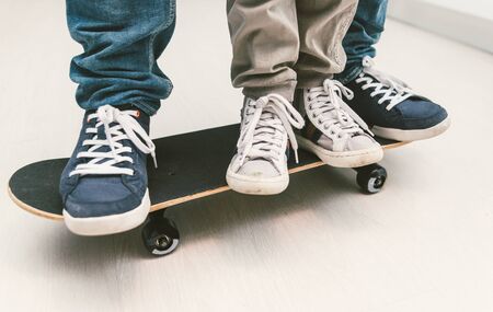 Father and son playing together on the skateboard. Teaching balance and playing together at home