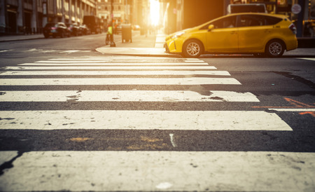 Focus on pedestrian lines in New york, with yellow cab in the backgroundの写真素材