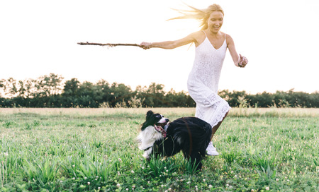 Beautiful blonde woman playing with her loyal border collieの写真素材