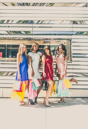 Multiethnic group of girls shopping - Four beautiful woman having fun while buying some presents in a mall in Beverly Hillsの写真素材