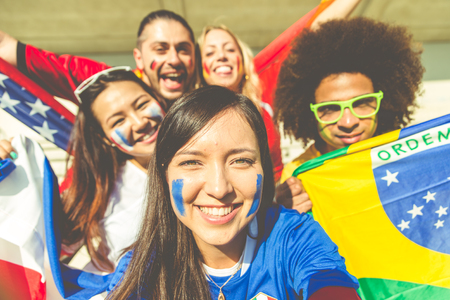 Group of mixed football fans taking selfies