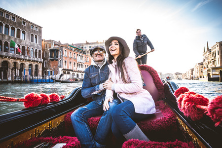 Couple of lovers on vacation in Venice, Italy - Tourists having a trip on a venetian gondolaの写真素材