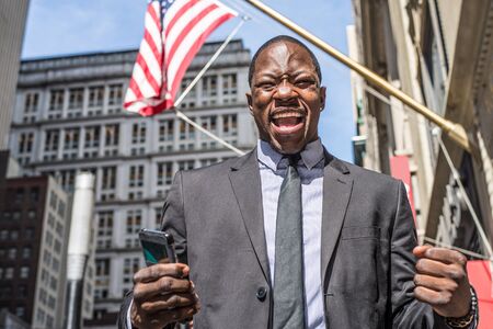 Businessman speaking at cellular phone outdoorsの写真素材