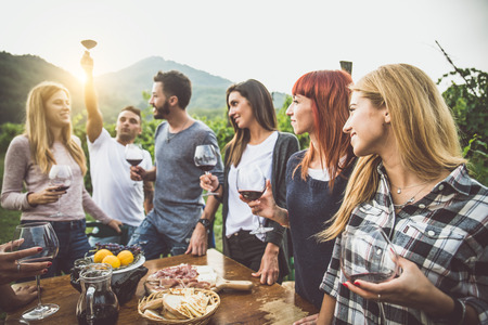 Group of friends at restaurant outdoors - People having dinner in a home gardenの写真素材