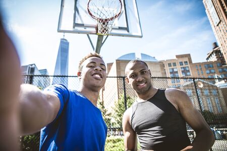 Two afroamerican athlethes playing basketball outdoors - Basketball athlete training on court in New Yorkの写真素材