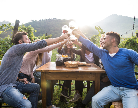 Group of friends at restaurant outdoors - People having dinner in a home gardenの写真素材
