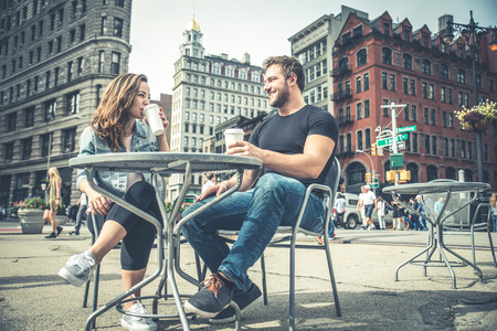 Couple dating in a coffeehouse bar in Manhattan - Tourists talking and having fun while sighseeing New Yorkの写真素材