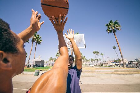 Friends playing basketball - Afro-american players having a friendly match outdoorsの写真素材