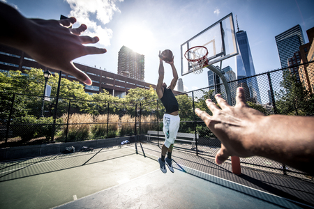 Two street basketball players playing hard on the court