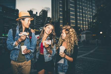 Multi-ethnic group of friends bonding outdoors - Young people walking and talking on the streetsの写真素材