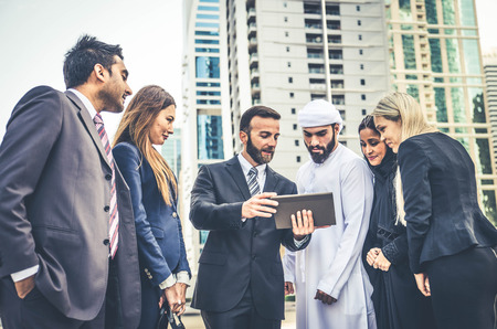 Multiethnic group of businesspeople meeting outdoors in a modern cityの写真素材