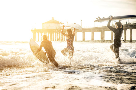 Group of friends going to surf at the beachの写真素材