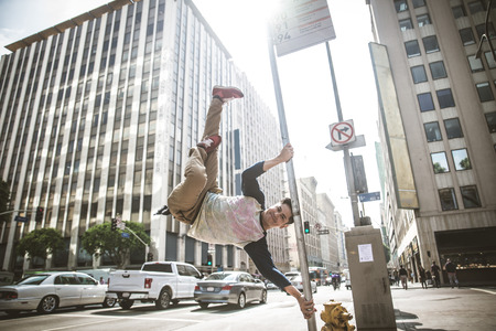 Parkour man doing tricks on the street - Free runner training his acrobatic port outdoors