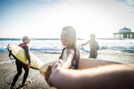 Group of friends going to surf at the beach