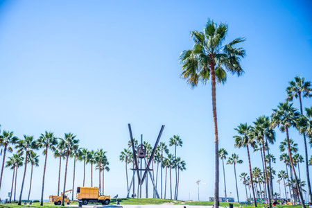 VENICE BEACH, USA - SEPTEMBER 29, 2016: The crowded Venice Beach Boardwalk. Lots of people are strolling down the boardwalk. On the sides there are several shops and palm trees.のeditorial素材