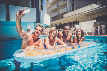 Multi-racial group of friends  having fun in a swimming poolの写真素材