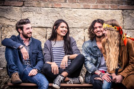 Young friends sitting on staircase having funの写真素材