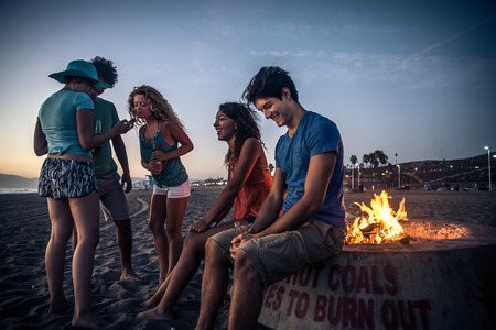 Multicultural group of friends partying on the beach - Young people celebrating during summer vacation, summertime and holidays conceptsの写真素材