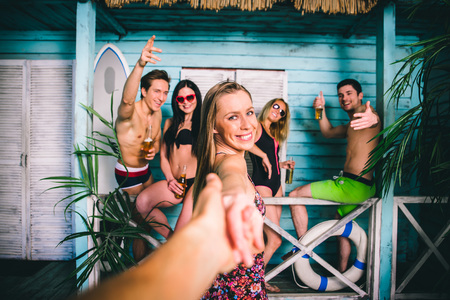 Group of five friends celebrating in their summer beach houseの写真素材