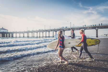 Group of friends going to surf at the beachの写真素材