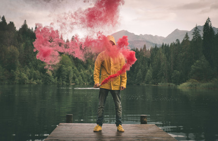 Man standing on the lake walkway with smoke bombの写真素材