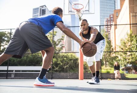 Two afroamerican athlethes playing basketball outdoors - Basketball athlete training on court in New Yorkの写真素材