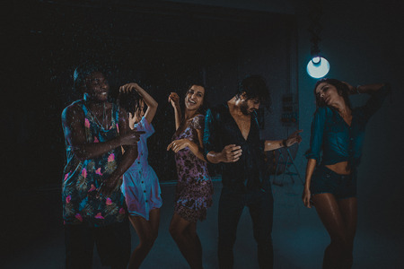 Group of friends dancing under the rain - Multiethnic people having partyの写真素材