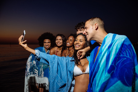 Group of friends taking night bath in the oceanの写真素材
