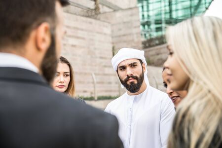 Multiethnic group of businesspeople meeting outdoors in a modern cityの写真素材