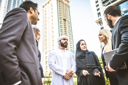 Multiethnic group of businesspeople meeting outdoors in a modern cityの写真素材