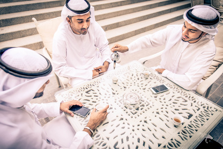 Three arabic men bonding outdoors - Businesspeople having a neeting in a bar restaurantの写真素材