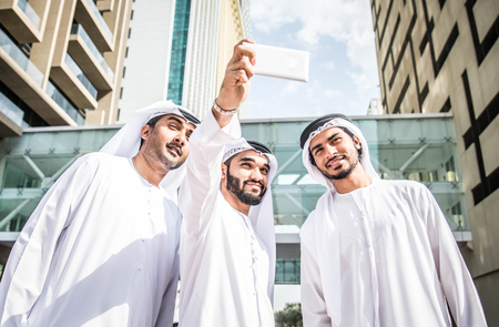 Three arabic men bonding outdoors - Businesspeople walking and talking in Dubaiの写真素材