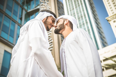 Three arabic men bonding outdoors - Businesspeople walking and talking in Dubai
