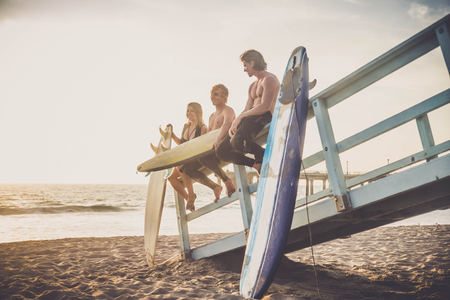 Group of friends going to surf at the beach - Young adults bonding at the beachの写真素材