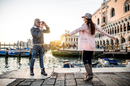 Beautiful couple in Venice, Italy - Lovers taking pictures with a vintage styled camera and having fun in Saint Mark Square, Veniceのeditorial素材