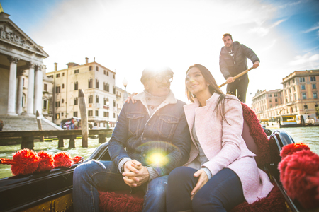 Couple of lovers on vacation in Venice, Italy - Tourists having a trip on a venetian gondolaの写真素材