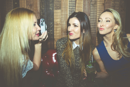 Party girls in a restaurant celebrating with drinks and champagneの写真素材