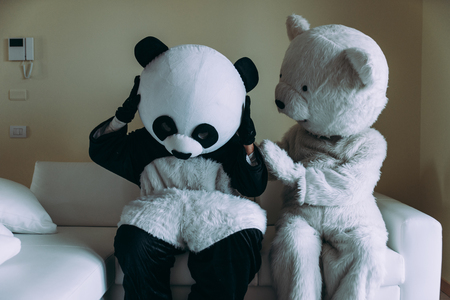 Men with animal costumes spending time inside the houseの写真素材