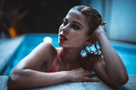 Beautiful girl taking night bath inside swimming pool