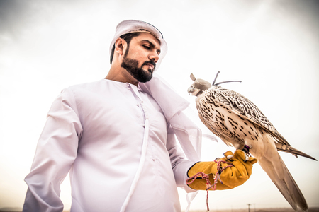 Arabian man walking  in the desert at sunriseの写真素材