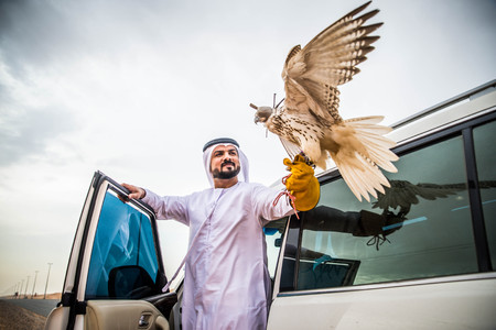 Arabian man walking  in the desert at sunriseの写真素材