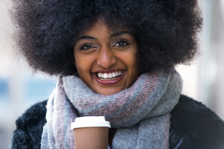 Beautiful woman drinking hot coffee - Afroamerican girl portrait outdoorsの写真素材