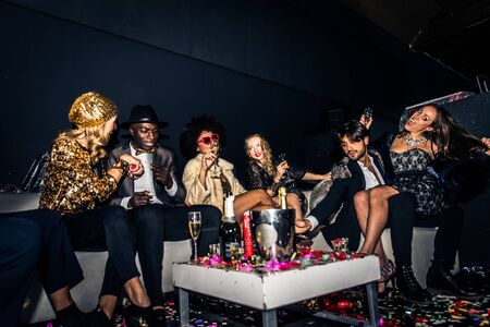Multi-ethnic group of friends celebrating in a nightclub - Clubbers having partyの写真素材