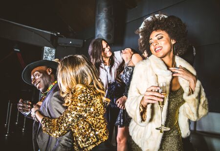Multi-ethnic group of friends celebrating in a nightclub - Clubbers having partyの写真素材