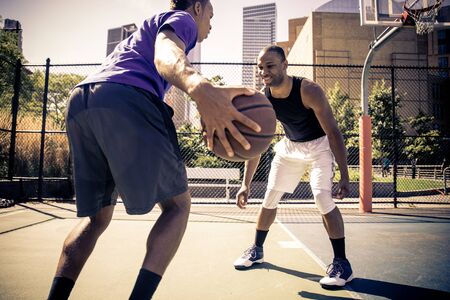 Two afroamerican athlethes playing basketball outdoors - Basketball athlete training on court in New Yorkの写真素材