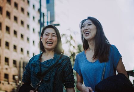 Two japanese women around in Tokyo during daytime. Making shopping and having funの写真素材